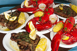 Plates of steak, corn and lobster